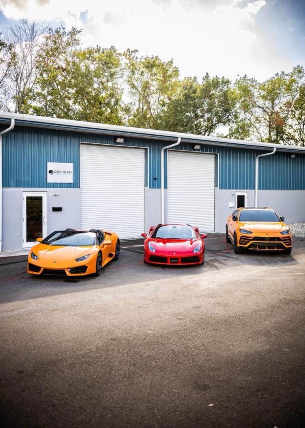 Exotic cars parked in front of the Obsidian Detail Studios bay doors