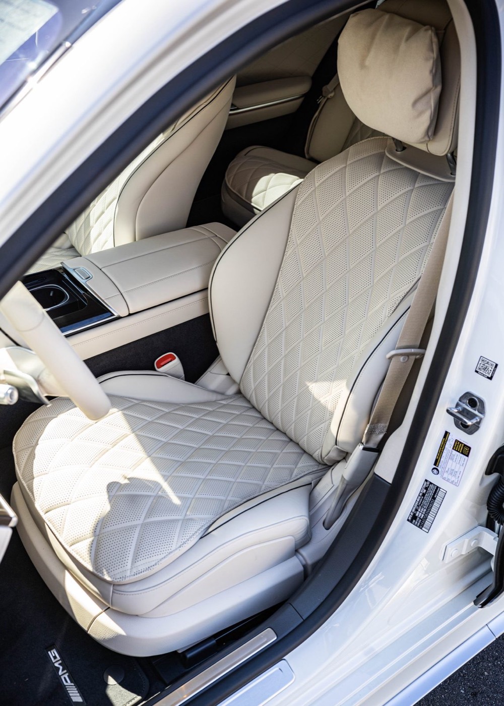 Cream quilted leather front seat and center console, seen through the open driver's door